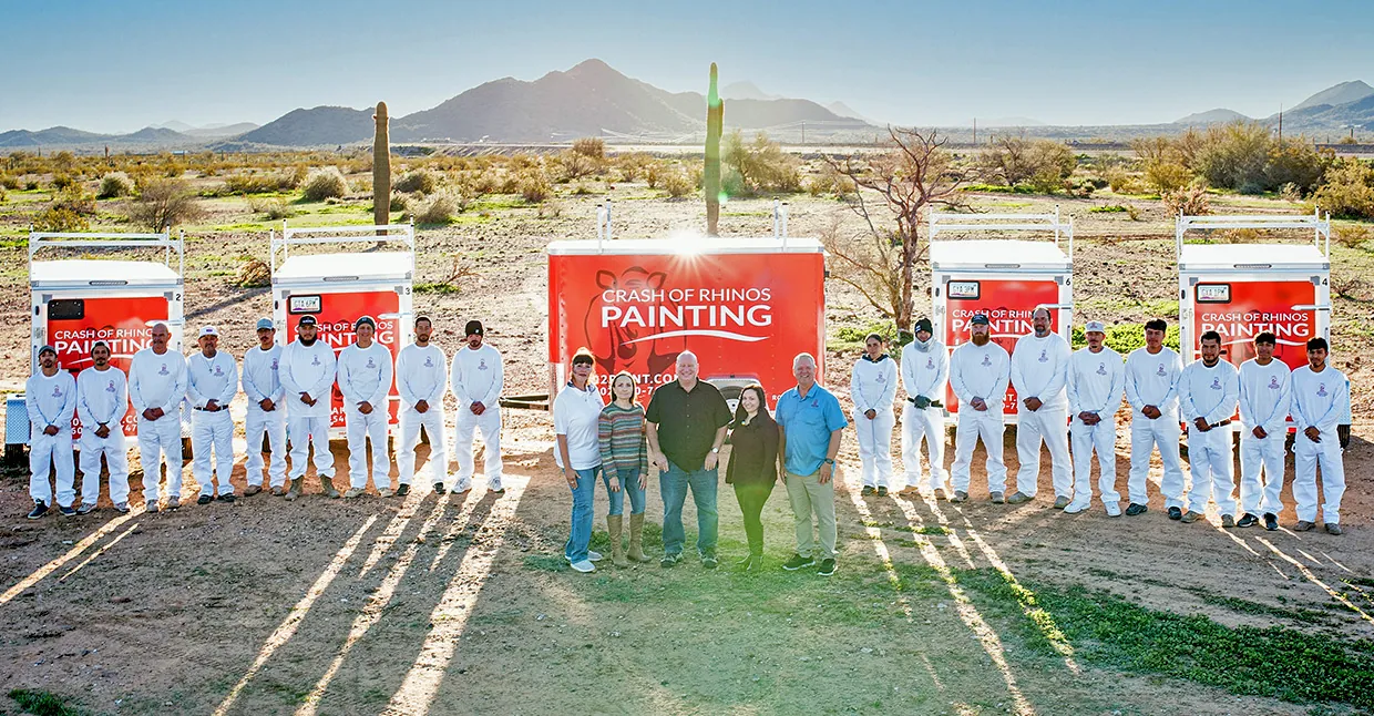 After: the Crash of Rhinos Painting crew in uniform lined up in front of their trucks and trailers