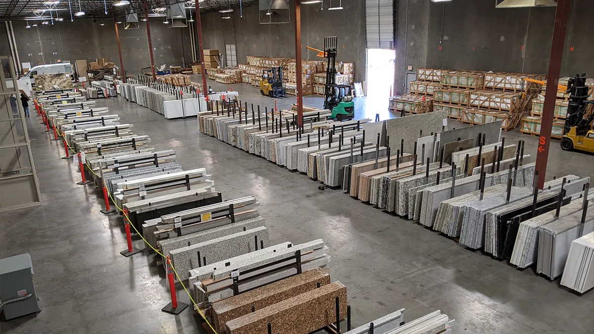 After: Superior Stone & Cabinet's larger warehouse with long aisles of stone slabs